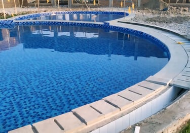 Kolam renang yang cantik dan indah dengan keramik berwarna biru dan air yang sangant jernih.
