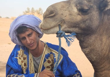 Ultimate Sahara co‑founder Hssein Liaichi with a camel in the Moroccan desert