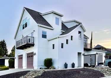 Corner perspective of a beautiful white French Revival architecture home.