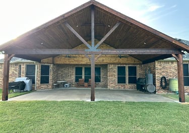 Larged covered patio with a vaulted wooden ceiling.