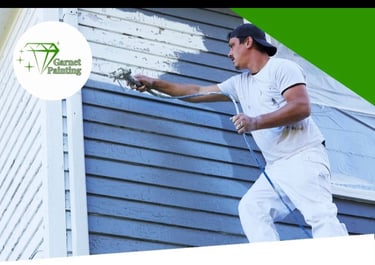 Garnet Painting team working on exterior house painting with company logo visible”