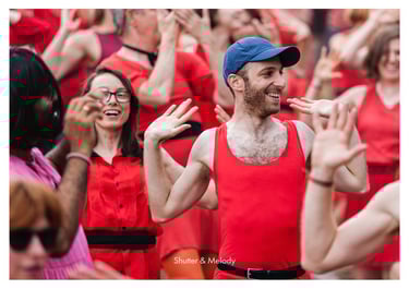 Ein Mann inmitten einer tanzenden Menge, der eine blaue Baseballkappe trägt.