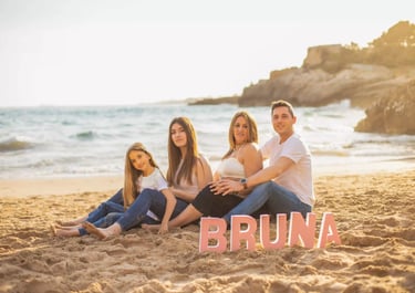 a family of three sitting on the beach