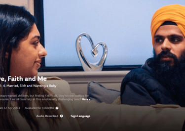 Screenshot of a BBC iPlayer show with two people talking on a sofa.