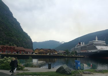 Porto de Flåm, Noruega — vista dos fiordes e navio de cruzeiro ancorado.