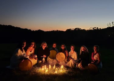 a group of women sitting around a candles at night