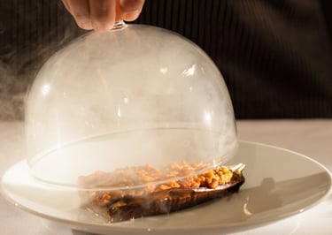 glass lid filled with smoke lifted off gormet meal 
