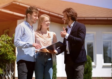 a man and woman standing in front of a house