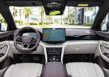Interior do BYD Song Plus DM-i com painel digital e vista para cenário urbano moderno