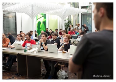 Die Teilnehmer des MTV Hack Day 2011 sitzen an Tischen.