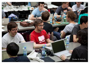 Die Teilnehmer der MTV Hack Days sitzen an Tischen.