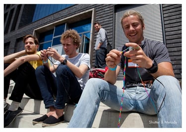 Die Teilnehmer des MTV Hack Day weben draußen in der Sonne.