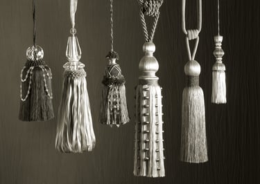 black and white image of ornate tassles against a textured fabric background