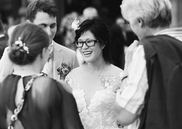 Vin d'honneur en noir et blanc, échanges souriants entre la mariée et ses invités.