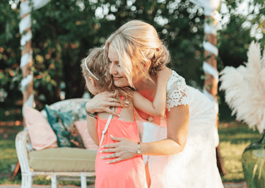 Moment tendre entre la mariée et une enfant durant le vin d'honneur.