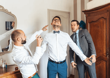 Préparatifs du marié avec ses témoins dans une ambiance joyeuse.