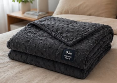 Folded dark grey 9kg weighted blanket with dotted minky fabric texture on a beige bed.