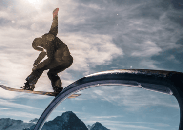 a snowboarder is riding a rail rail in the mountains