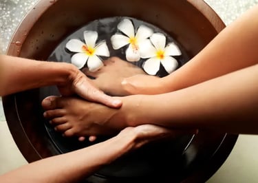 Someone's feet in a bowl of water getting a foot massage.