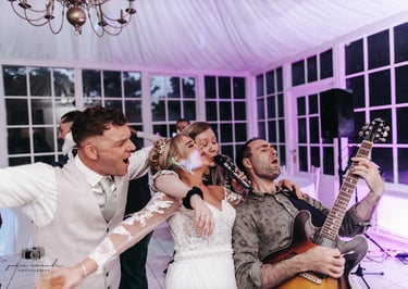 Bride and groom having fun with wedding singer musicians and band