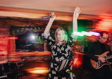 Female wedding party singer dancing with her arms up