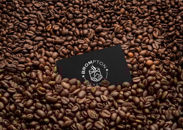 a business card with a coffee cup on top of a pile of coffee beans