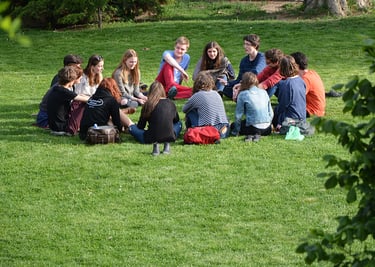Groupe de personnes assis en cercle sur l'herbe
