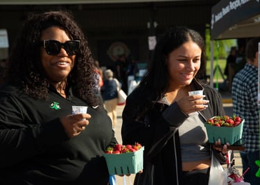 Two adults leaving the farmers market enjoying our bike-powered smoothies