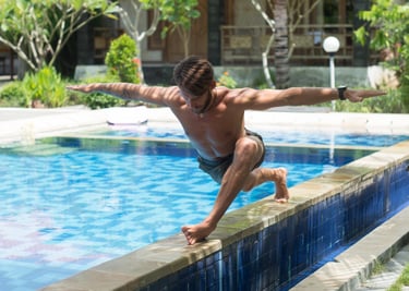 a man is doing a yoga pose on a pool side