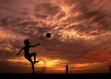 a person jumping up in the air with a ball