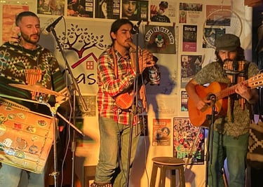 Banda de folk en vivo interpretando música tradicional andina con zampoñas, flauta y guitarra 
