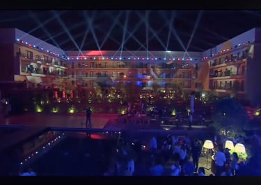 a man standing in front of a pool with a crowd of people