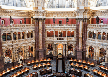 An ornate historic library interior with multiple levels of bookshelves and classical architecture