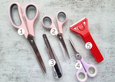 A set of five card making tools: 3 pairs of scissors, craft knife and glass scraper