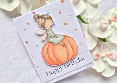 Cute handmade greeting card with adorable cute little fall fairy sitting on a pumpkin.