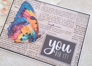 Handmade greeting card with a butterfly, newspaper background and "You Did It" printable sentiment.
