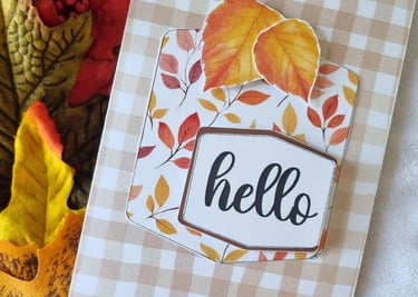 Fall greeting card with "hello" text, featuring autumn leaves in red, yellow, and orange