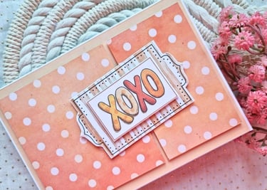 Handmade greeting card with orange background and white dots. Sentiment "XOXO" is in the center.