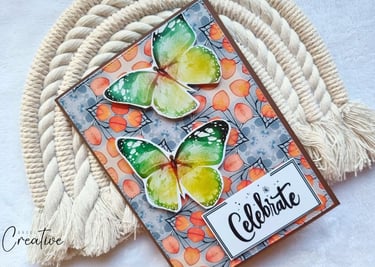 Handmade greeting card with fall colors background, two butterlies and a sentiment "Celebrate"