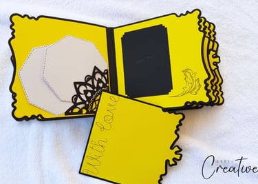 Bright yellow handmade album with scalloped edges, featuring black floral cutouts, a "With Love" mes