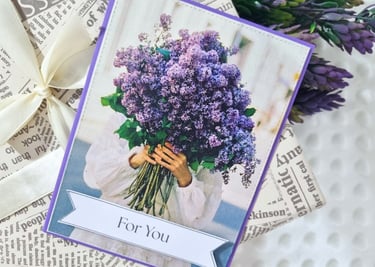 A magazine page of a person in a white dress holding a large bouquet of purple flowers.