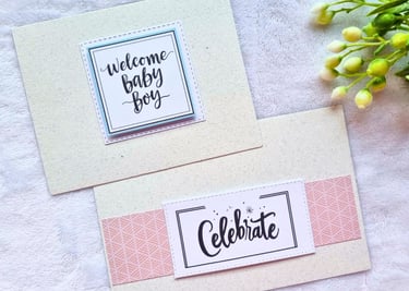 Two handmade greeting cards with "Celebrate" and "Welcome Baby Boy" sentiments on it