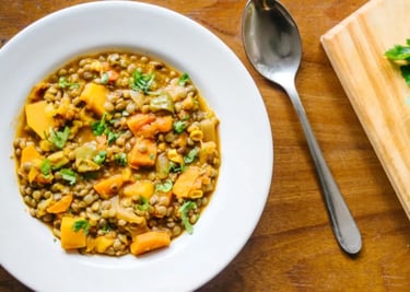 Prato fundo com sopa de lentilha e legumes frescos