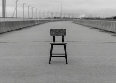 Una silla vacía de madera en medio de la nada.