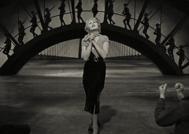Joan Blondell singing “Remember My Forgotten Man” with WWI soldiers on a dramatic stage bridge.
