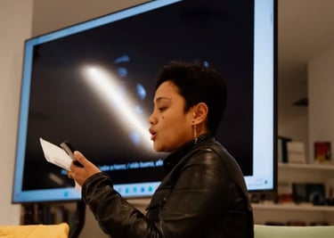 una mujer negra con jaqueta de cuero sujetando un papel y un móvil