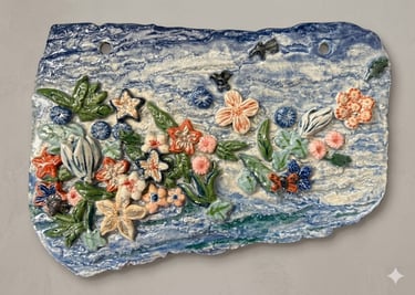 Ceramic plaque of tropical flowers floating on ocean waves, titled Tides of Aloha.