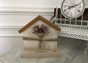 décoration en bois en forme de maison avec des fleurs séchées