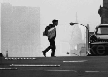 A newsboy crosses the street in Center City Philadelphia in the 1960s by James Drake