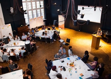 Ein Redner und ein Tisch bei einer Veranstaltung in Refugio Berlin.